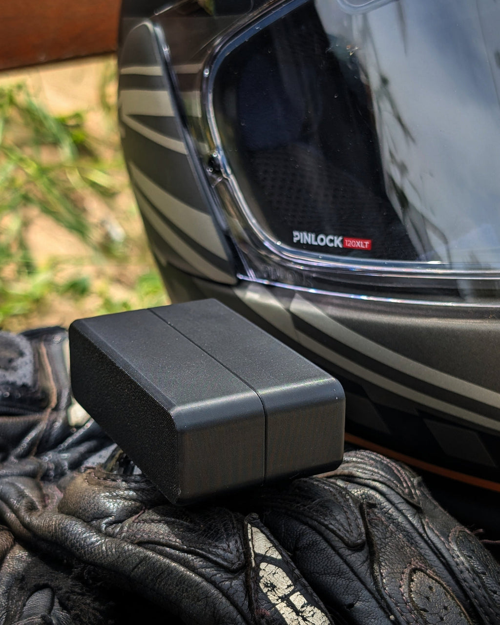 moto via verde em preto ao lado de capacete e luvas