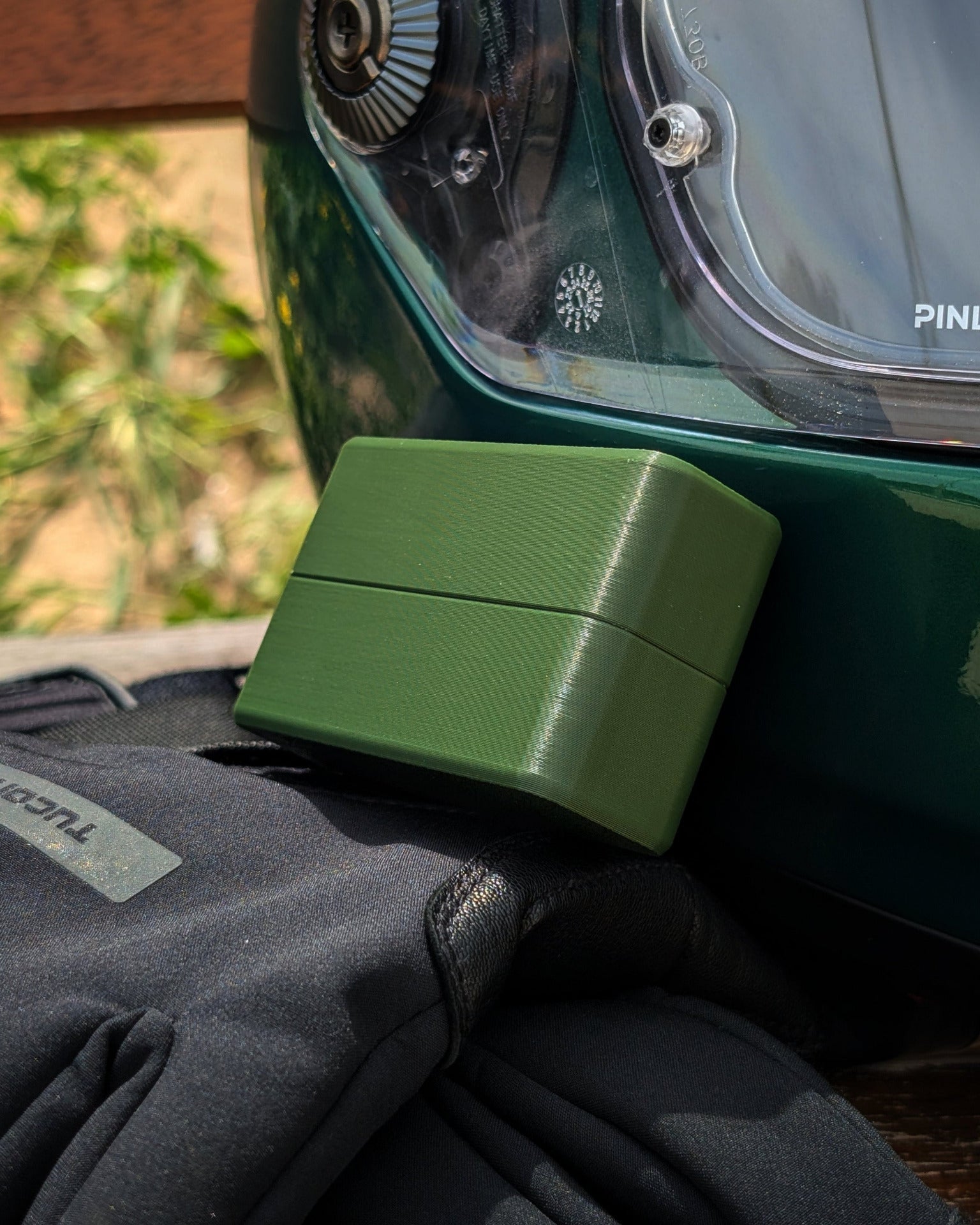 moto via verde em verde escuro ao lado de capacete e luvas